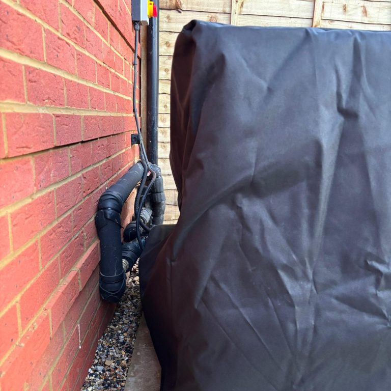 Black heat protection cover with blue text displaying "HEAT PUMP PROTECTORS" and a website URL.