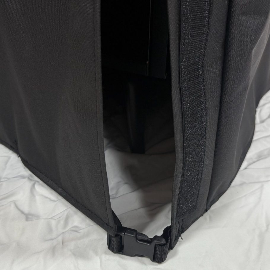A partially unzipped black fabric cover.