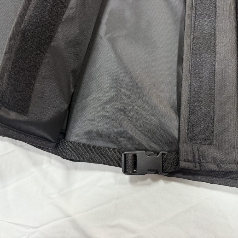 Close-up of a black fabric with straps and a buckle detail.